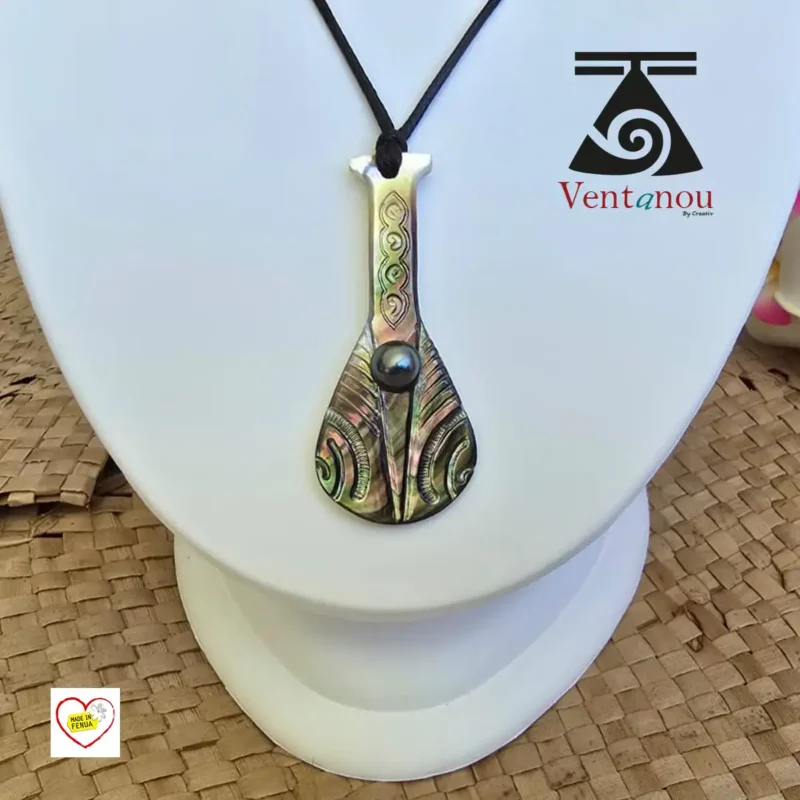 collier-pour-homme-en-nacre-et-perle-noire-de-tahiti Pendentif polynésien en forme de rame paddle, en nacre de Bora Bora et perle noire, présenté sur cordon noir